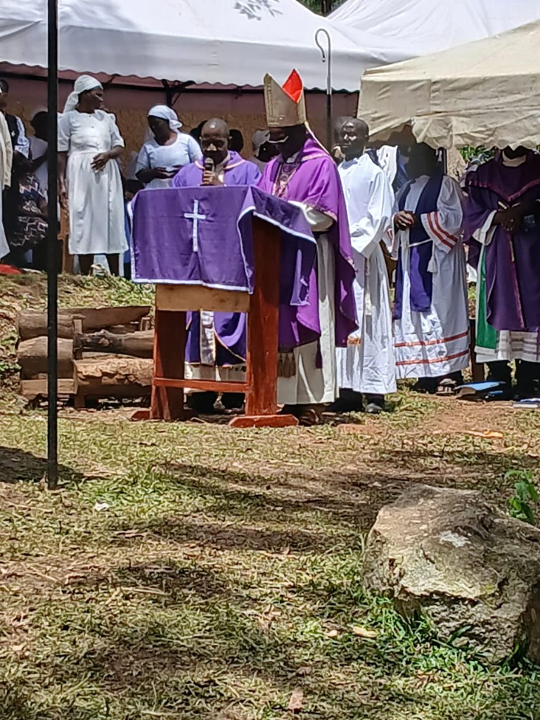 Bishop at lectern funeral Veronica Ogot